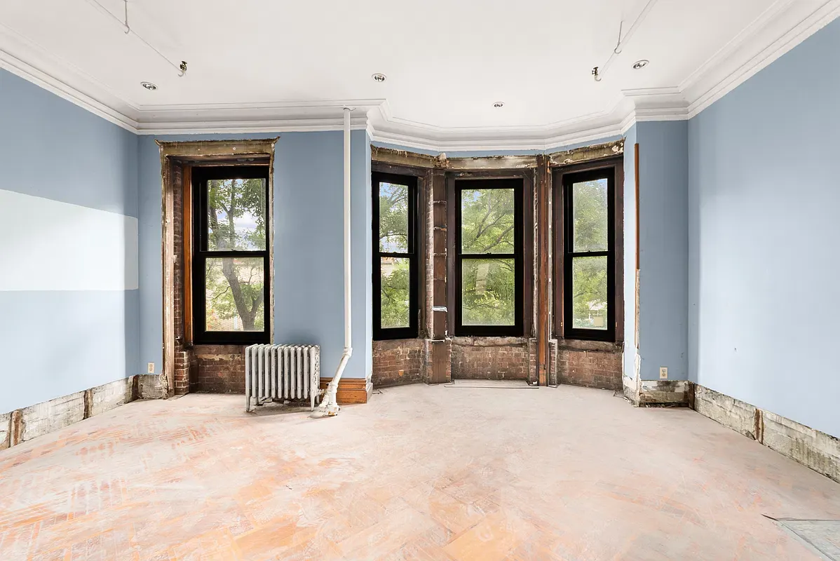 Unrenovated room with a three-window bay at 128 West 121st Street