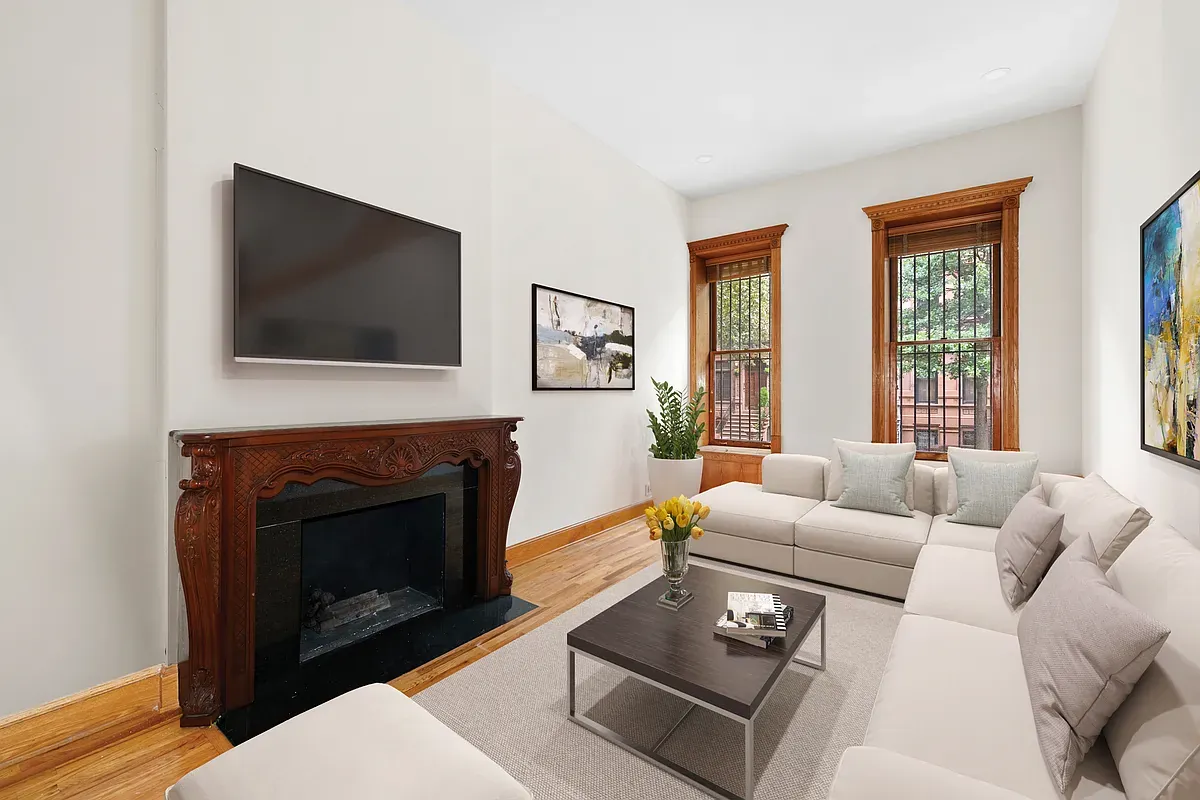 Virtually staged living room with carved wood mantel at 14 West 121st Street