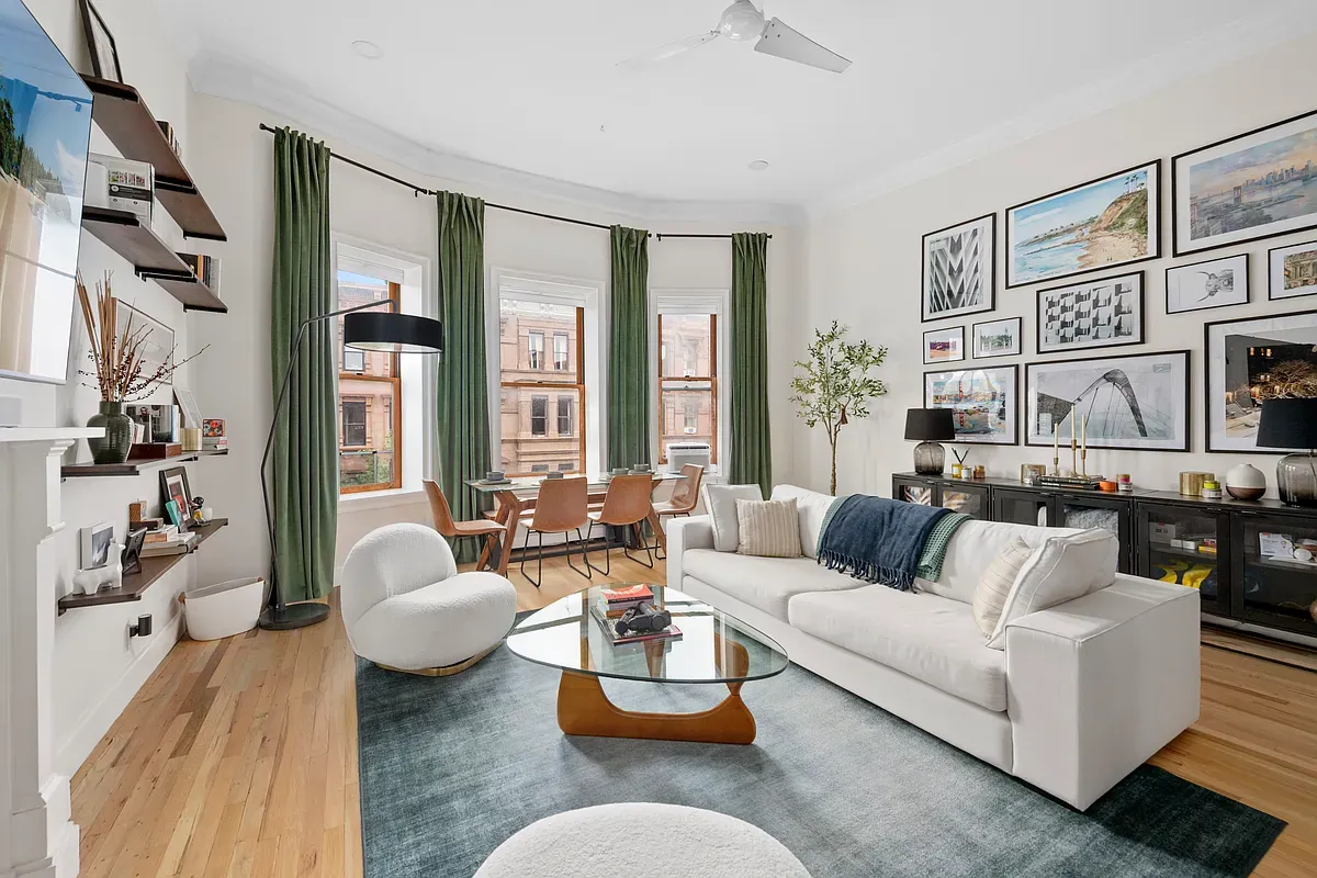 Living room with bay windows and wood floors at 14 West 121st Street