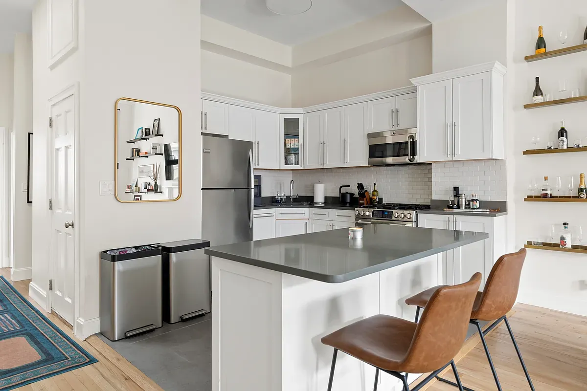 White kitchen with breakfast bar at 14 West 121st Street