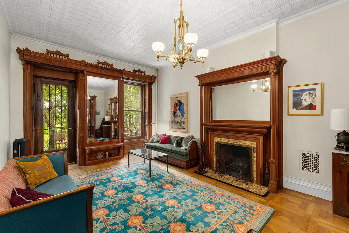 Parlor living room with original woodwork and fireplace at 360 West 121st Street
