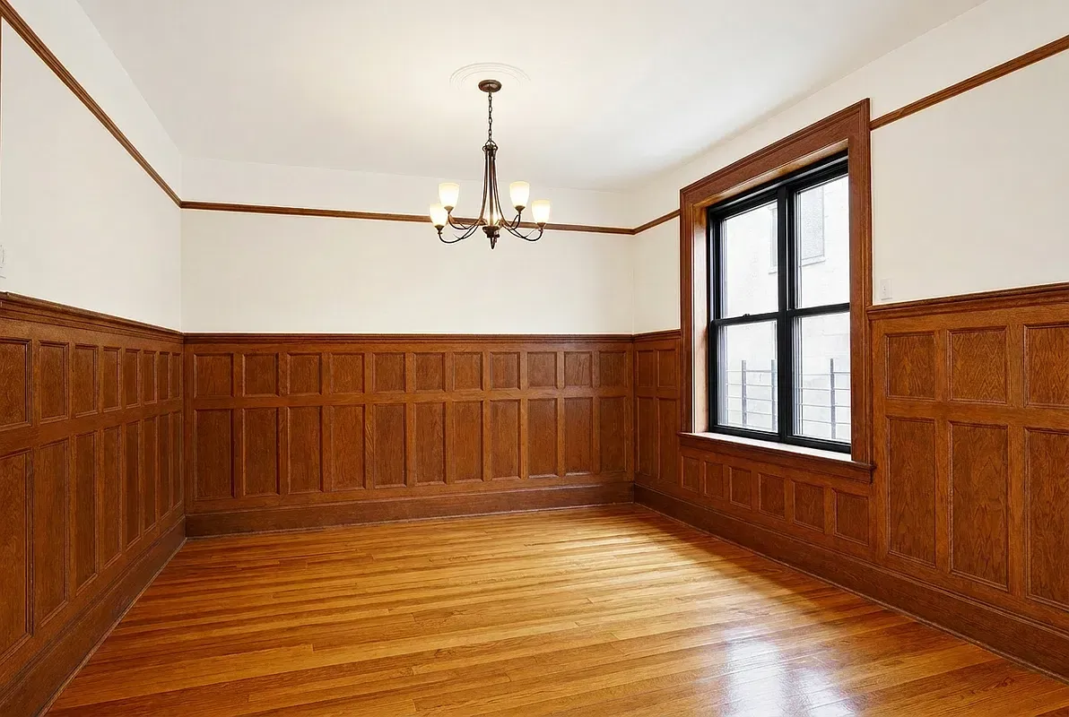 Empty dining room with oak wainscoting at 523 West 121st Street #2