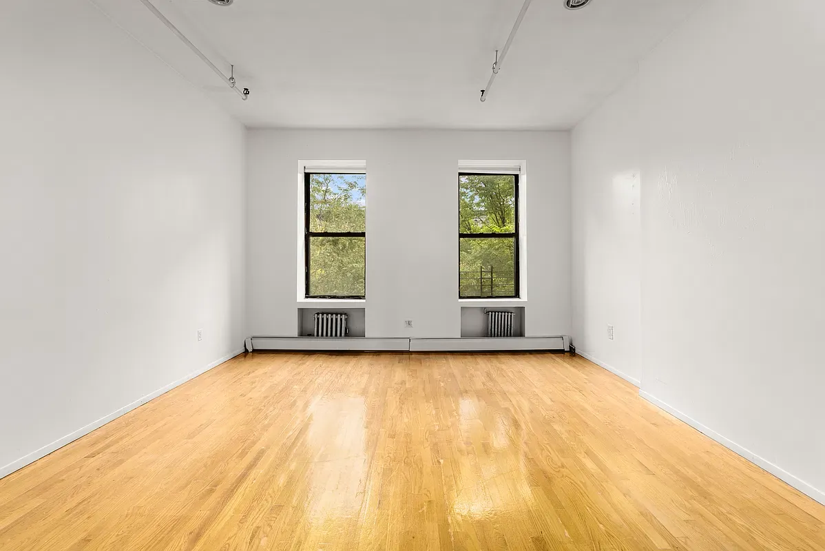 Empty room with two windows at 80 West 119th Street