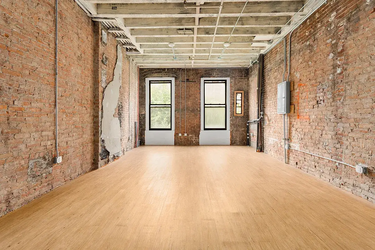 Open floor with exposed brick walls at 80 West 119th Street