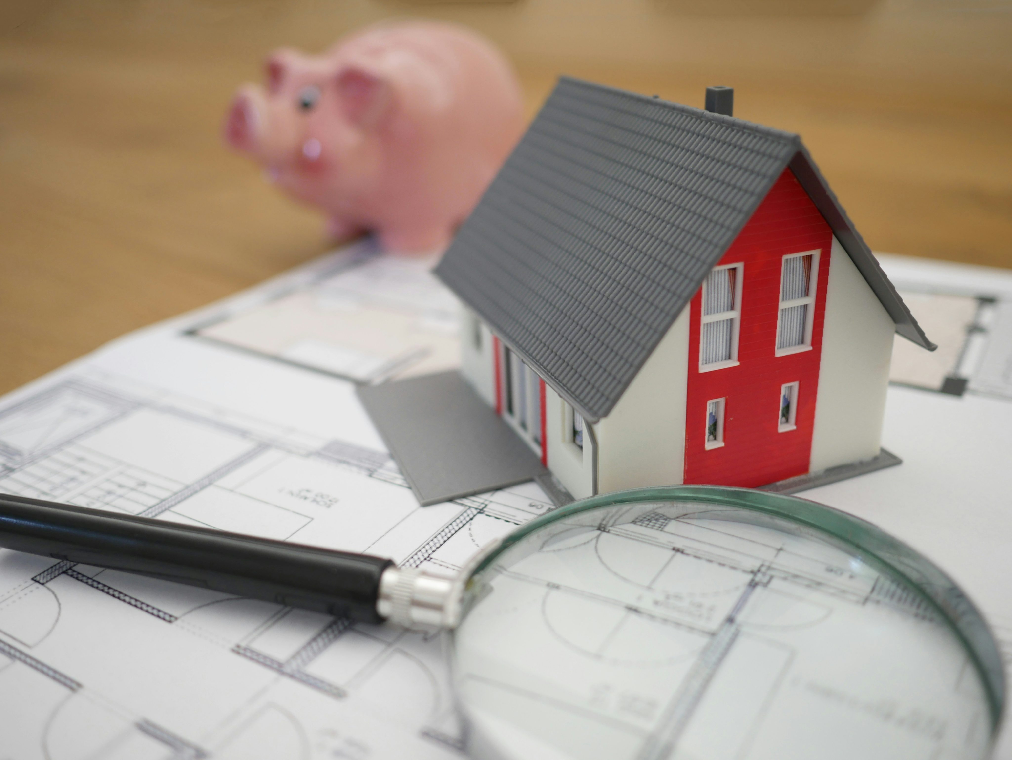 NYC real estate investment planning with house model, architectural plans, and financial savings concept for property buyers